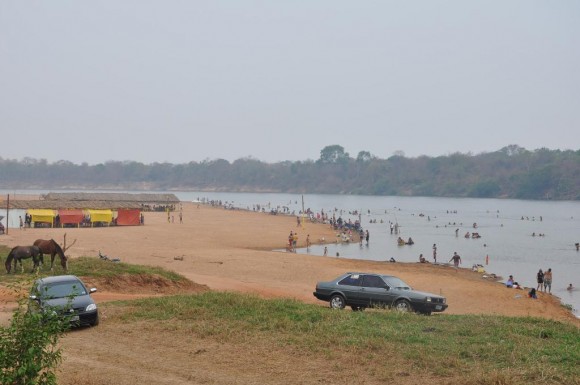 Imprópria para o banho humano, banhistas se refrescam na praia Bar